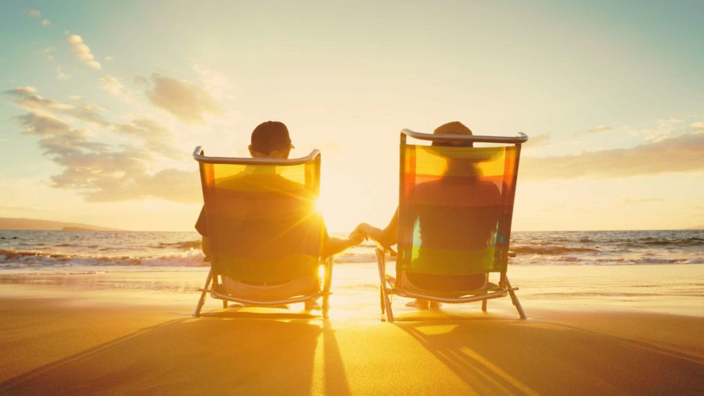 Couple relaxing on beach at sunset