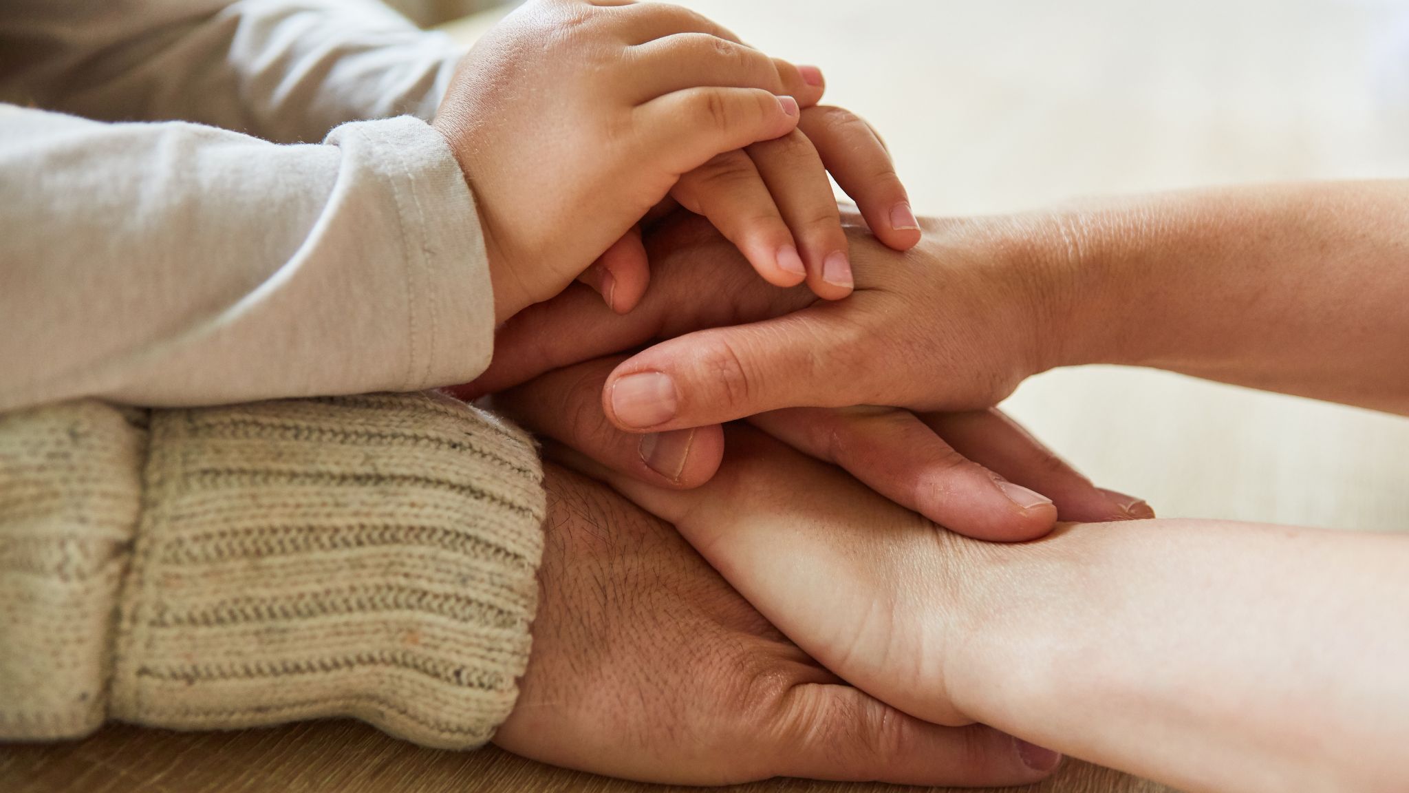 Close up of several generations of a family holding hands